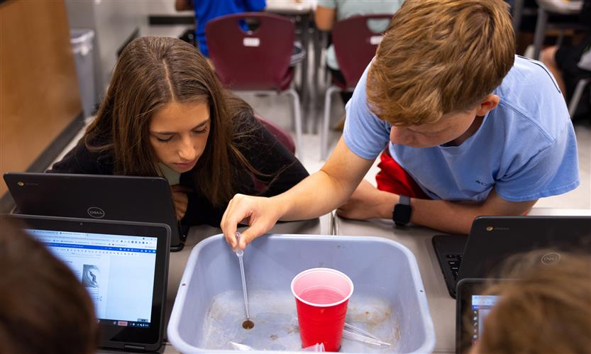 Two students drop water onto pennies